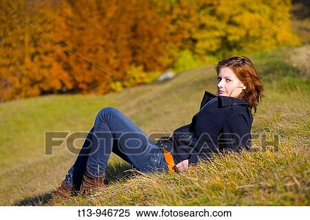 Pretty young woman is lying on grass isolated in Autumn View Large Photo Image Stock Photography - Pretty young woman is lying on grass isolated in Autumn. Fotosearch