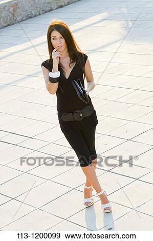 Pretty young woman is waiting in the street View Large Photo Image Stock Photo - Pretty young woman is waiting in the street. Fotosearch