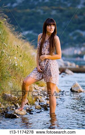 Pretty young woman is walking on the coastline View Large Photo Image Stock Photo - Pretty young woman is walking on the coastline. Fotosearch