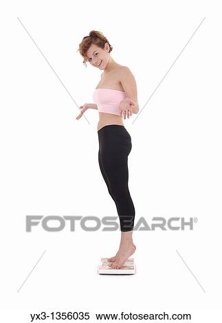 Pretty young woman on scale, isolated on white background View Large Photo Image Stock Photography - Pretty young woman on scale, isolated on white background. Fotosearch