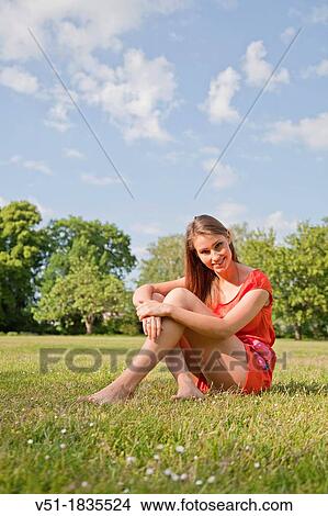 Picture - Pretty young woman relaxing in park. Fotosearch