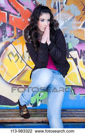 Pretty young woman standing on the wooden bench before a colorful wall View Large Photo Image Stock Image - Pretty young woman standing on the wooden bench before a colorful wall. Fotosearch