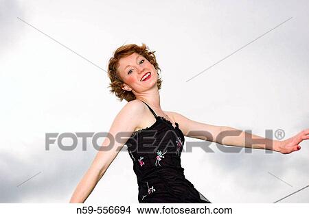 Picture - Pretty young woman walking in party dress.. Fotosearch
