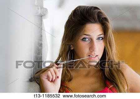 Pretty young woman with a chain necklace in her mouth View Large Photo Image Stock Image - Pretty young woman with a chain necklace in her mouth. Fotosearch