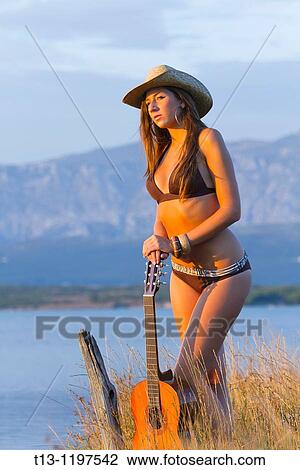 Pretty young woman with a guitar on the beach in the sunset time View Large Photo Image Stock Image - Pretty young woman with a guitar on the beach in the sunset time. Fotosearch