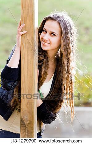 Stock Image - Pretty young woman with a long curly hair is happy. Fotosearch
