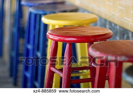 Stock Photo - primary colored stools await bar patrons at an outside beach bar. Fotosearch