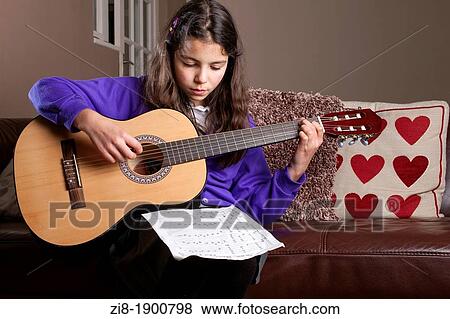 Primary schoolgirl practicing guitar View Large Photo Image Stock Photo - Primary schoolgirl practicing guitar. Fotosearch