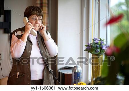 Professional nurse of a Rotterdam nursing home, having a conversation over the phone with one of her colleagues. View Large Photo Image Stock Image - Professional nurse of a Rotterdam nursing home, having a conversation over the phone with one of her colleagues.. Fotosearch