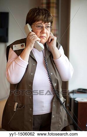 Professional nurse of a Rotterdam nursing home, having a conversation over the phone with one of her colleagues. View Large Photo Image Stock Image - Professional nurse of a Rotterdam nursing home, having a conversation over the phone with one of her colleagues.. Fotosearch