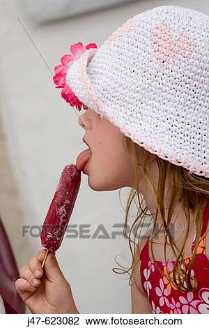Stock Image - profile of a 4 year old girl licking a lolly. Fotosearch