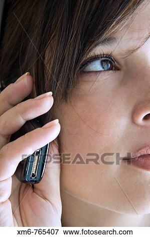 Profile of Young executive speaking on his cellphone while looking out the window View Large Photo Image Stock Photo - Profile of Young executive speaking on his cellphone while looking out the window. Fotosearch