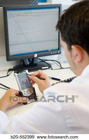 Stock Photo - Programmer working with PDA. Project to promote personal autonomy in the domestic field. Fatronik Foundation, Research Technology Center. Donostia, San Sebastian, Gipuzkoa, Euskadi. Spain.. Fotosearch