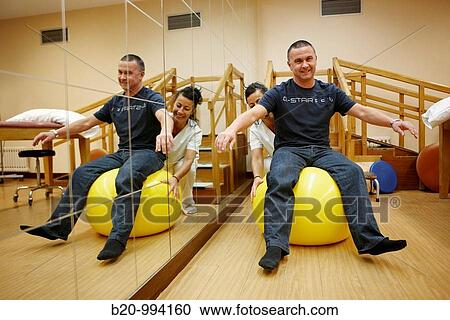 Stock Image - Proprioception training with exercise ball, reeducation exercise, rebahilitation. Policlinica Gipuzkoa, San Sebastian, Donostia, Euskadi, Spain. Fotosearch