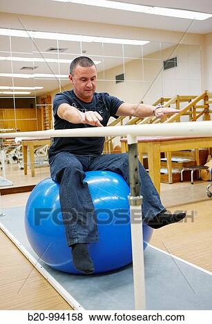 Stock Photo - Proprioception training with exercise ball, reeducation exercise, rebahilitation. Policlinica Gipuzkoa, San Sebastian, Donostia, Euskadi, Spain. Fotosearch