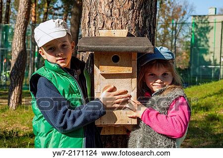 Proud children holding birdhouse. View Large Photo Image Picture - Proud children holding birdhouse.. Fotosearch