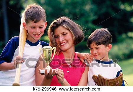 Proud mom holds sons? softball trophy View Large Photo Image Stock Photograph - Proud mom holds sons? softball trophy. Fotosearch