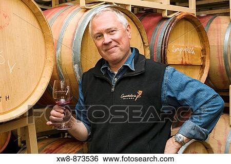 Stock Photograph - Proud winemaker in barrel room of winery. Fotosearch