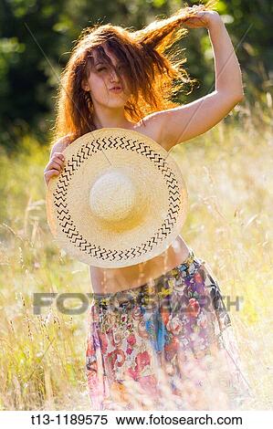 Provocative young woman is standing in the grass field, pulling hair View Large Photo Image Stock Photography - Provocative young woman is standing in the grass field, pulling hair. Fotosearch
