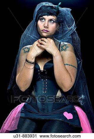 Stock Image - Punk Bride in her late 20s in a studio setting wearing a black wedding dress. Fotosearch