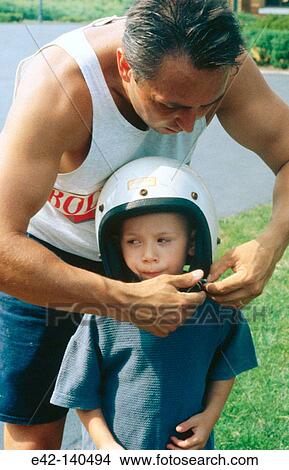 Putting on a helmet View Large Photo Image Picture - Putting on a helmet. Fotosearch