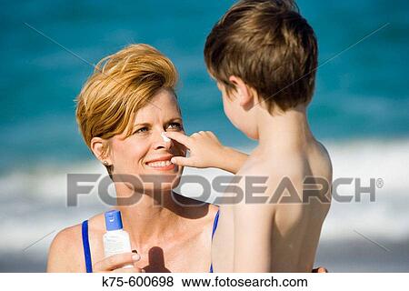 Putting suntan lotion on mom's nose View Large Photo Image Stock Photo - Putting suntan lotion on mom's nose. Fotosearch