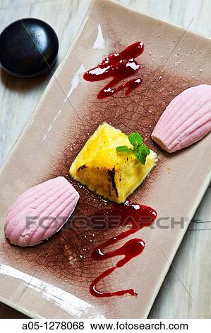 Stock Photo - Pyramid? creme brulee? with lemon grass, served with ice yoghourt mixed with raspberry Green Tangerine Restaurant Old City Hanoi Vietnam.. Fotosearch