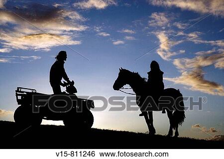 Stock Photograph - Quad bike and horse rider on ridge. Fotosearch