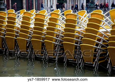 Stock Photo - Quadri's reastaurant chairs during high tide in St Mark's square, acqua alta, Venice, Italy, Europe. Fotosearch