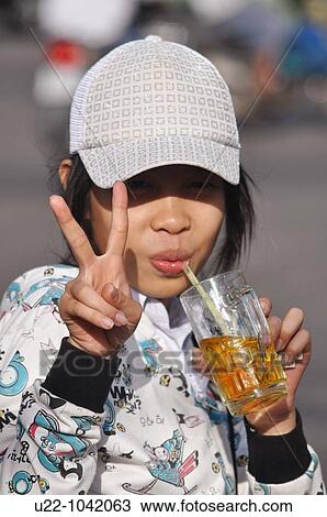 Rach Gia (Vietnam): a girl making the? V? gesture while drinking View Large Photo Image Stock Image - Rach Gia (Vietnam): a girl making the? V? gesture while drinking. Fotosearch