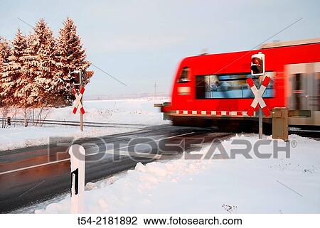 Railcar of the Deutsche Bahn AG passes a level crossing on a winter day View Large Photo Image Stock Image - Railcar of the Deutsche Bahn AG passes a level crossing on a winter day. Fotosearch