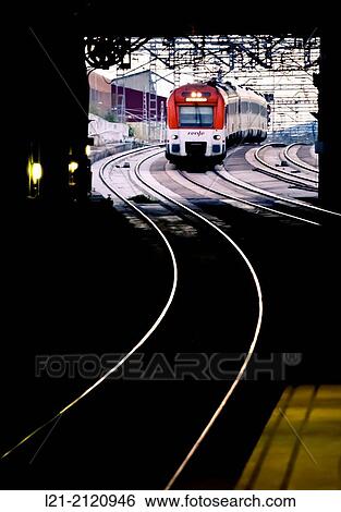 Stock Photograph - Railroad tracks and Renfe train at sunset. Barcelona province, Catalonia, Spain.. Fotosearch