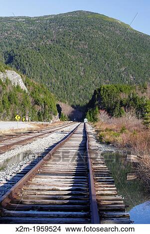 Railroad tracks next to Crawford Train Depot (Conway Scenic Railroad) at the start of Crawford Notch State Park in the White Mountains, New Hampshire USA. The rock profile known as "Elephant Head" can be seen on the left. View Large Photo Image Picture - Railroad tracks next to Crawford Train Depot (Conway Scenic Railroad) at the start of Crawford Notch State Park in the White Mountains, New Hampshire USA. The rock profile known as "Elephant Head" can be seen on the left.. Fotosearch