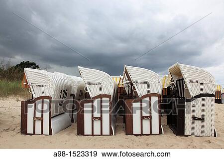 rain clouds above roofed wicker beach chair at the sandy coast of the isle of Usedom, Western Pomerania, Germany, Europe View Large Photo Image Stock Photo - rain clouds above roofed wicker beach chair at the sandy coast of the isle of Usedom, Western Pomerania, Germany, Europe. Fotosearch