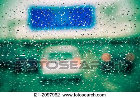 Rain drops on windshield. Blurred view of cars on a highway. View Large Photo Image Stock Image - Rain drops on windshield. Blurred view of cars on a highway.. Fotosearch