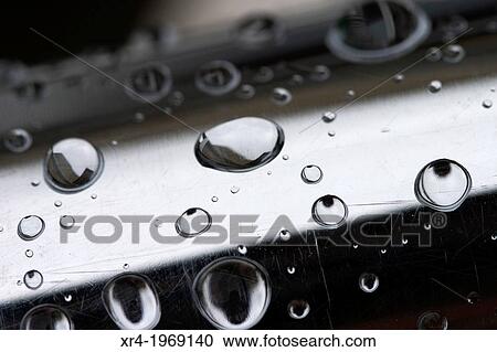 Stock Image - Raindrops over a metal tube. Fotosearch