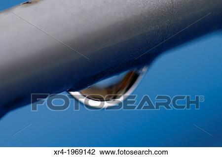 Stock Image - Raindrops over a metal tube. Fotosearch