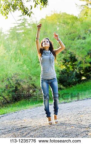 Reaching for the branch young woman View Large Photo Image Stock Photograph - Reaching for the branch young woman. Fotosearch