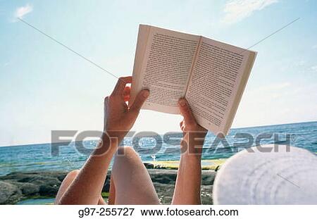 Stock Photo - Reading at the beach. Fotosearch