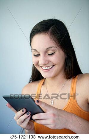 Stock Image - Reading on e-book tablet. Fotosearch