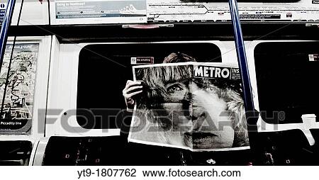 Reading the newspaper inside a subway car View Large Photo Image Stock Image - Reading the newspaper inside a subway car. Fotosearch