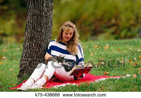 Reading with her cat on lap View Large Photo Image Stock Photograph - Reading with her cat on lap. Fotosearch