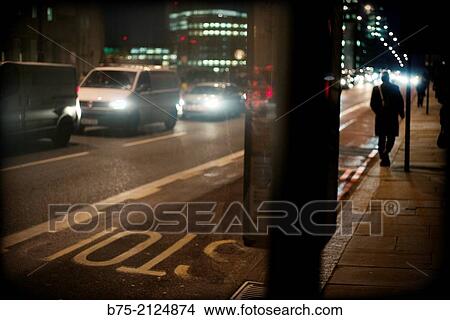 rear view of a man walking in London Bridge with traffic and text of bus stop in the asphalt in London, England, UK View Large Photo Image Picture - rear view of a man walking in London Bridge with traffic and text of bus stop in the asphalt in London, England, UK. Fotosearch