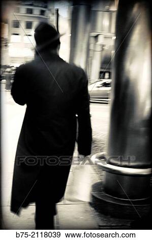 Rear view of a unrecognizable man walking down the street and talking on the phone in London, England, UK, Europe. View Large Photo Image Stock Photo - Rear view of a unrecognizable man walking down the street and talking on the phone in London, England, UK, Europe.. Fotosearch
