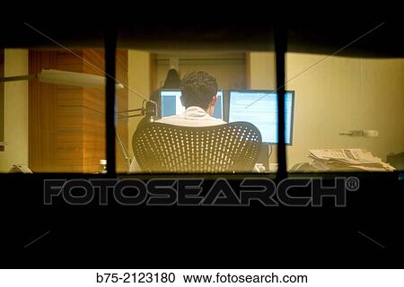 rear view of an unrecognizable man seen through a window in an office working with computer in London, England, UK, Europe. View Large Photo Image Stock Image - rear view of an unrecognizable man seen through a window in an office working with computer in London, England, UK, Europe.. Fotosearch