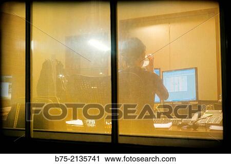 Rear view of an unrecognizable woman working in an office with a computer and drinking water seen through a window in The City, London, England, UK, Europe View Large Photo Image Stock Image - Rear view of an unrecognizable woman working in an office with a computer and drinking water seen through a window in The City, London, England, UK, Europe. Fotosearch