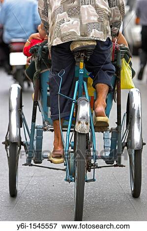 Rear view of cyclo rickshaw and driver Ho Chi Minh City Vietnam View Large Photo Image Stock Photo - Rear view of cyclo rickshaw and driver Ho Chi Minh City Vietnam. Fotosearch