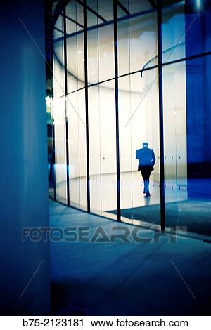 Stock Image - rear view of one unrecognizable executive in the lobby of an office building in London, England, UK, Europe.. Fotosearch