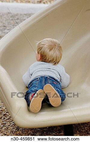 Stock Image - Rear view of toddler on slide. Fotosearch