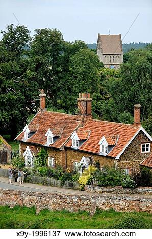 Red Brick Cottages With Dormer Windows And Gardens And Church Of